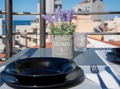 a table with a plate and a vase with purple flowers at Stelios Florans Apartment in Chania Town