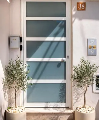 a front door of a house with two potted plants at Stelios Florans Apartment in Chania Town