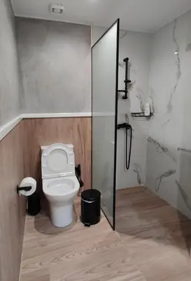 a bathroom with a toilet and a glass shower stall at Modern Central Apartment - 400m to Beach in Kissamos