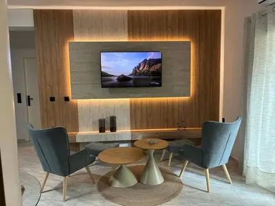 a living room with a table and a tv on a wall at Karadinos Apartment in Stílos