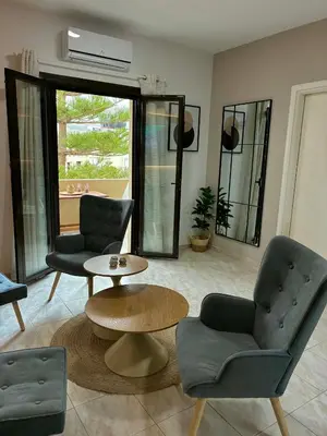 a living room with two chairs and a table at Karadinos Apartment in Stílos