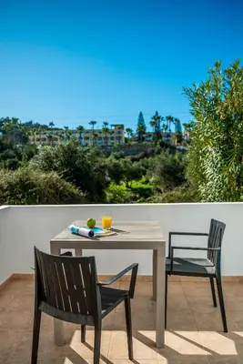 a table and two chairs on a patio with a view at Almyrida Bayview VII - BY APOKORONAS VILLAS in Almirida
