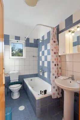 a bathroom with a tub and a toilet and a sink at Almyrida Bayview VII - BY APOKORONAS VILLAS in Almirida