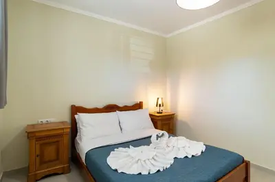 a bedroom with a bed with white sheets and two night stands at Almyrida Bayview VII - BY APOKORONAS VILLAS in Almirida