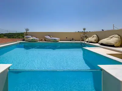 a blue swimming pool on top of a building at Villa Metochi with Private Pool in Palio Gerani