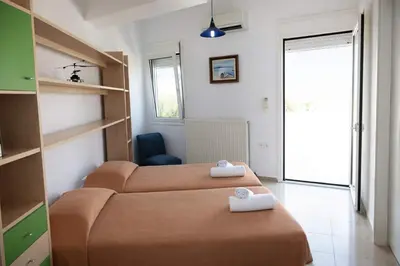 a small room with two beds and a window at Villa Joy Mare - Seaside Escape with Private Pool in Aghii Apostoli
