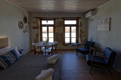 a living room with a bed and a table and chairs at Vecia Abasia - The Old Abbey in Chania Town