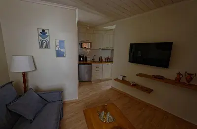 a living room with a couch and a flat screen tv at Vecia Abasia - The Old Abbey in Chania Town