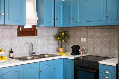 a kitchen with blue cabinets and a sink at 3 Sails - 2BR on Venetian Harbour with Balcony in Chania Town