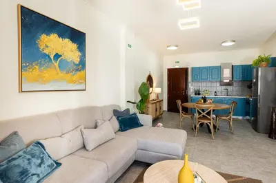 a living room with a couch and a kitchen at 3 Sails - 2BR on Venetian Harbour with Balcony in Chania Town