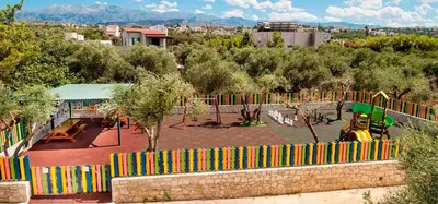 a playground with a colorful fence in a park at Sirios Village Hotel & Bungalows - All Inclusive in Kato Daratso