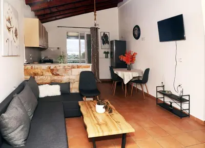 a living room with a couch and a table at Komvos Apartment in Souda