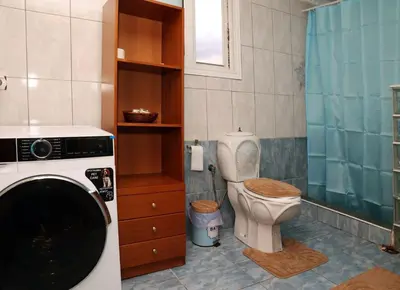 a bathroom with a toilet and a washing machine at Komvos Apartment in Souda