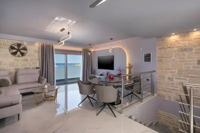 a living room with a table and a couch and a tv at Armdin Seaview Villa 1 in Módhion