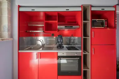 a red kitchen with red cabinets and a sink at Armdin Seaview Villa 3 in Módhion
