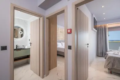 a room with a bedroom with a bed and a bathroom at Armdin Seaview Villa 3 in Módhion