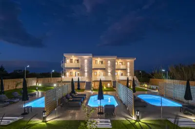 a hotel with a swimming pool at night at Armdin Seaview Villa 3 in Módhion