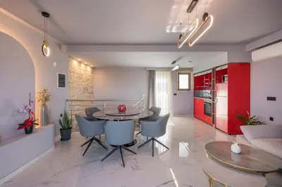 a kitchen and living room with a table and chairs at Armdin Seaview Villa 3 in Módhion