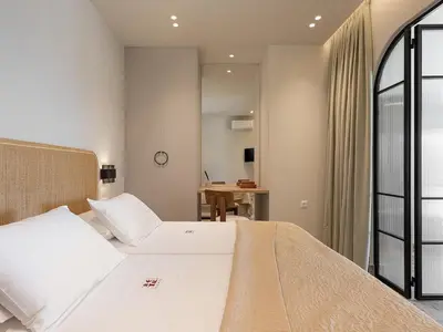 a bedroom with a large bed and a desk at Casa Viento in Ravdhoúkha