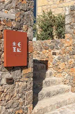 a sign on the side of a stone wall at Casa Viento in Ravdhoúkha