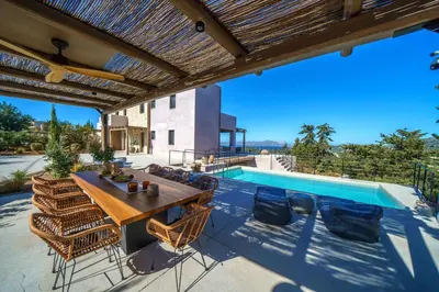 a patio with a table and chairs and a swimming pool at EAST VILLA by CYAMES in Gavalochori