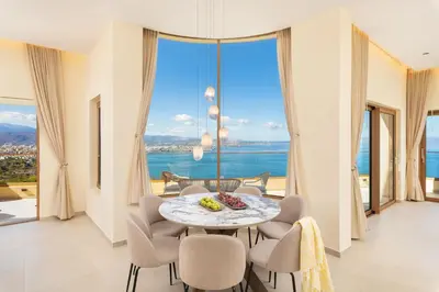 a dining room with a table and chairs and a large window at BelSodi - 3bedroom sea views and heated pool in Chania Town