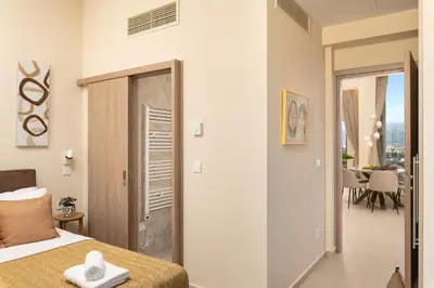 a bedroom with a bed and a door leading to a dining room at BelSodi - 3bedroom sea views and heated pool in Chania Town
