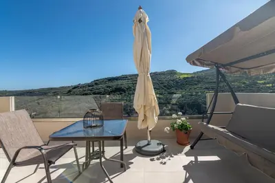 a patio with a table and chairs on a balcony at Victoria Luxury Residence in Kissamos
