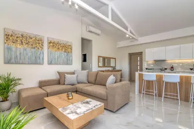 a living room with a couch and a kitchen at Victoria Luxury Residence in Kissamos