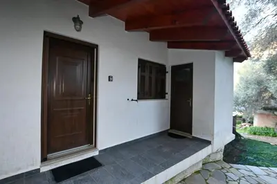 a house with a wooden door and a porch at Chania Hillside 2BD Home - Nature & Comfort by ΜΡS