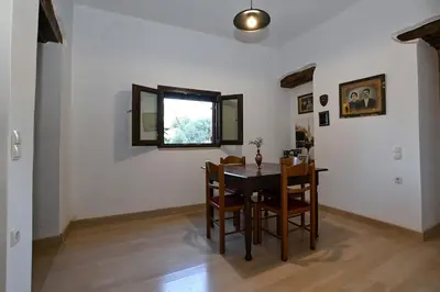 a dining room with a table and chairs and a window at Chania Hillside 2BD Home - Nature & Comfort by ΜΡS