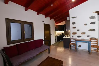 a living room with a couch and a kitchen at Chania Hillside 2BD Home - Nature & Comfort by ΜΡS