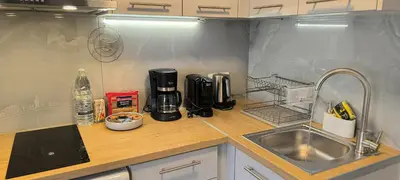 a kitchen counter with a coffee maker and a sink at Cozy Apartment with Private Jacuzzi - Fiber Internet - Private Parking in Chania Town