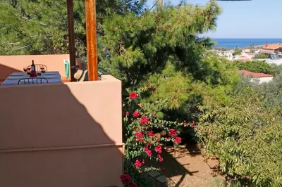 a view from the balcony of a house with flowers at Glaros Home in Kato Daratso