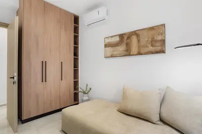 a living room with a couch and a wooden cabinet at Elan Stay in Chania Town