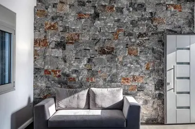 a living room with a couch against a brick wall at Aloni Villa with pool Kefalas in Vamos