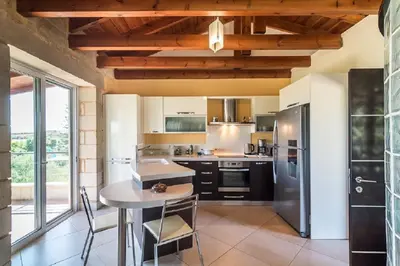 a kitchen with a table and a refrigerator at Villa Chara Chania in Agia Marina Nea Kydonias
