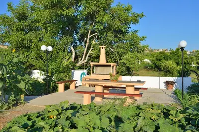 a picnic table and a bench in a garden at Sofoklis Apts in Stalos