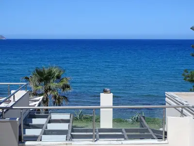 a set of stairs leading to the ocean at Kalyves Sand- Beach front apartment in Kalyves