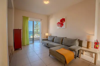 a living room with a couch and a table at Kalyves Sand- Beach front apartment in Kalyves