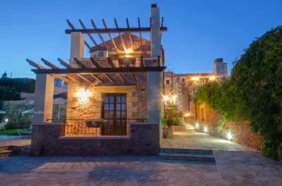 a building with a balcony on the side of it at night at Aretaki villas in Astrátigos
