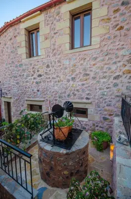 a stone building with a fountain in front of it at Aretaki villas in Astrátigos