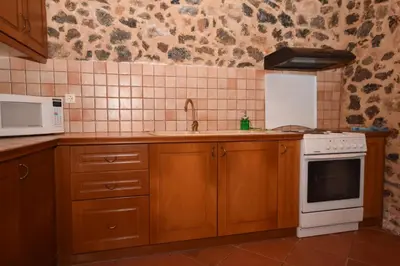 a kitchen with a stove and a sink and a microwave at Aretaki villas in Astrátigos