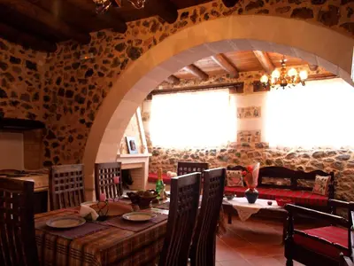 a dining room with a table and a stone wall at Aretaki villas in Astrátigos