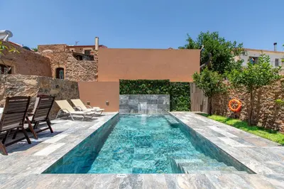 a swimming pool in the backyard of a house at Aretaki villas in Astrátigos