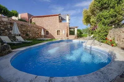 a swimming pool in front of a house at Aretaki villas in Astrátigos