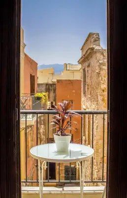 a table on a balcony with a potted plant at Iason Studios in Chania Town