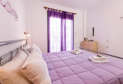 a large pink bed in a room with a window at Paleochora Apartments in Palaiochóra