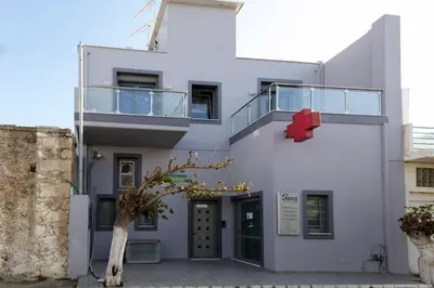a white building with a red object on the side at Paleochora Apartments in Palaiochóra
