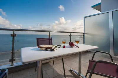 a table with two glasses of wine on a balcony at Paleochora Apartments in Palaiochóra